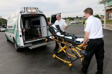 EMTs placing a gurney in an ambulance
